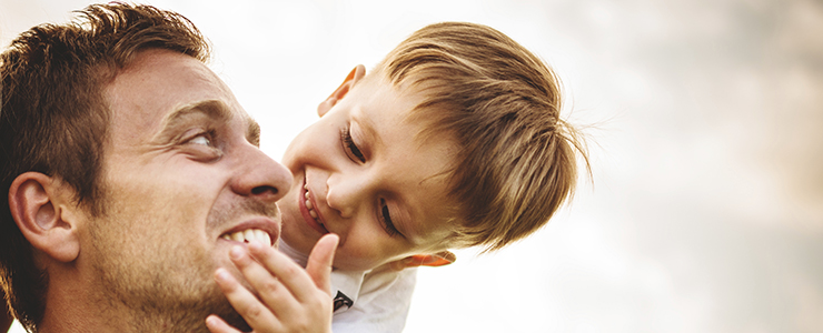 Image of father looking at his son and smiling
