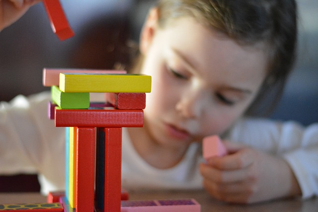 young child playing with building blocks