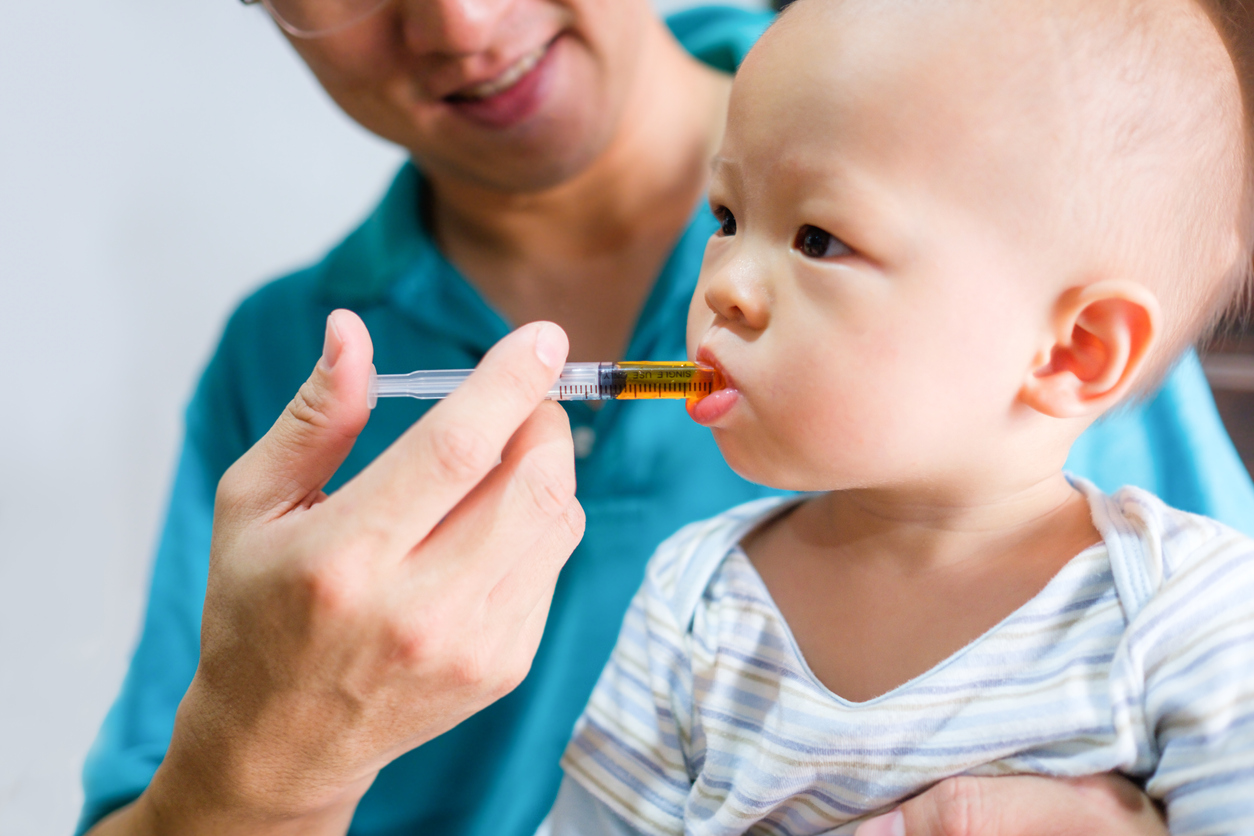 A doctor administering medicine to an infant.