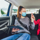 tennage year and young boy sitting in the backseat of a vehicle wearing seatbelts