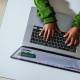child typing on laptop