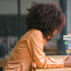 Girl leaning on desk using her cell phone