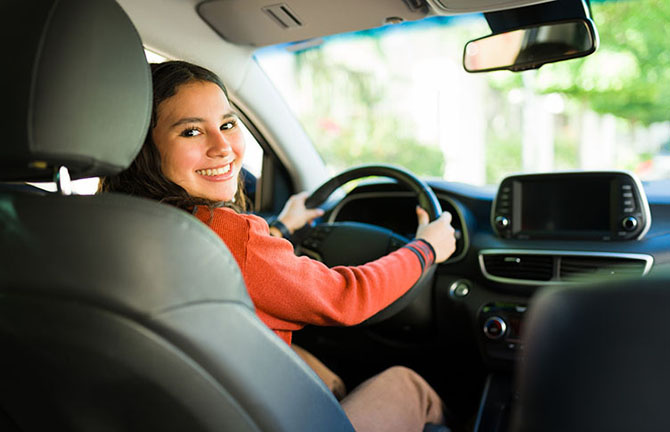teen in the driver seat looking backwards