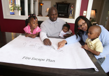 Black family going over their family fire escape plan with their kids