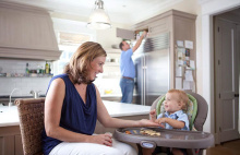 mother with baby and dad behind accessing a cabinet