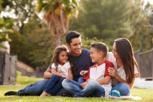 Smiling family sitting outdoors